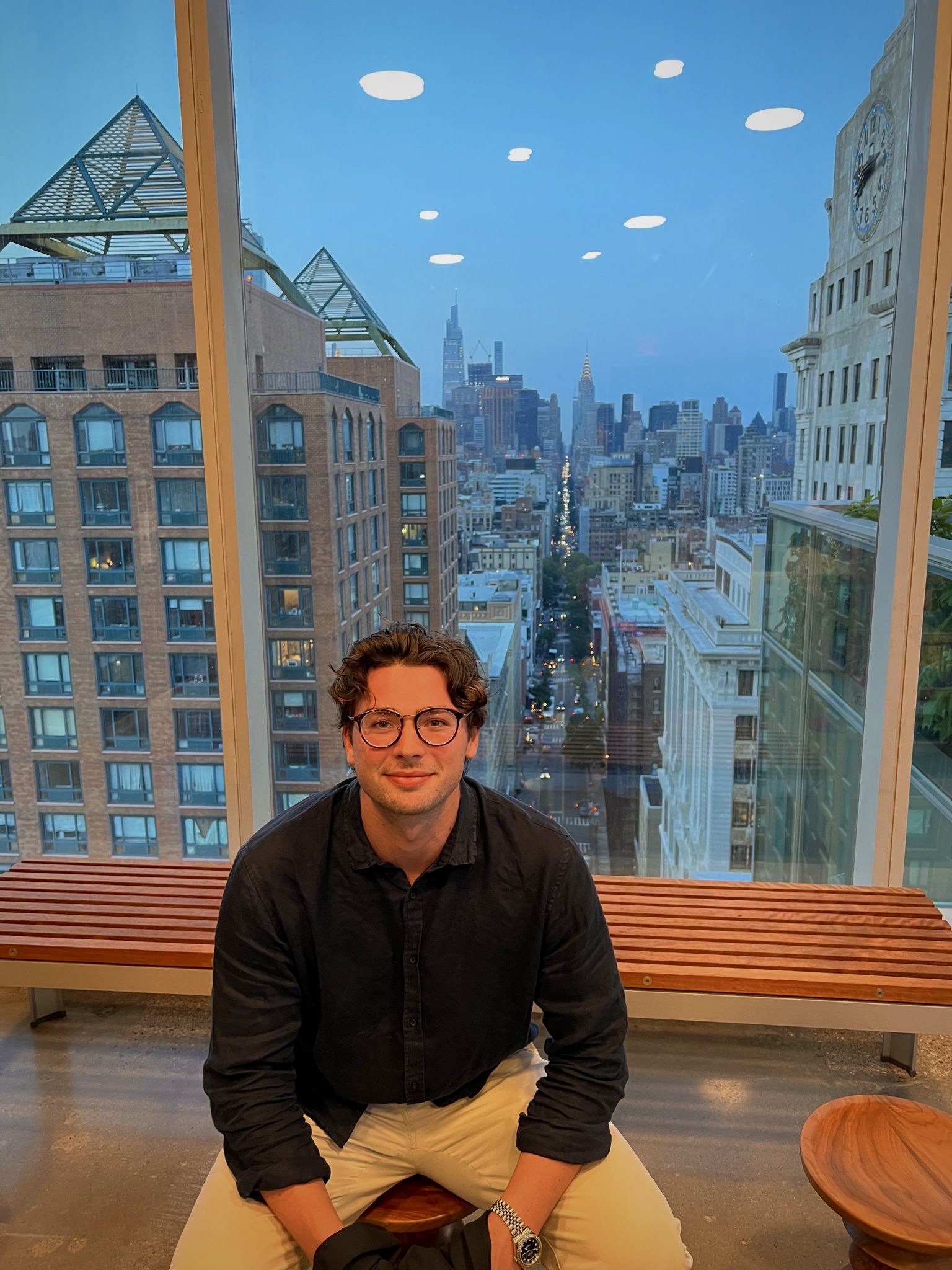 Photo of Jack O'Donoghue seated in front of cityscape